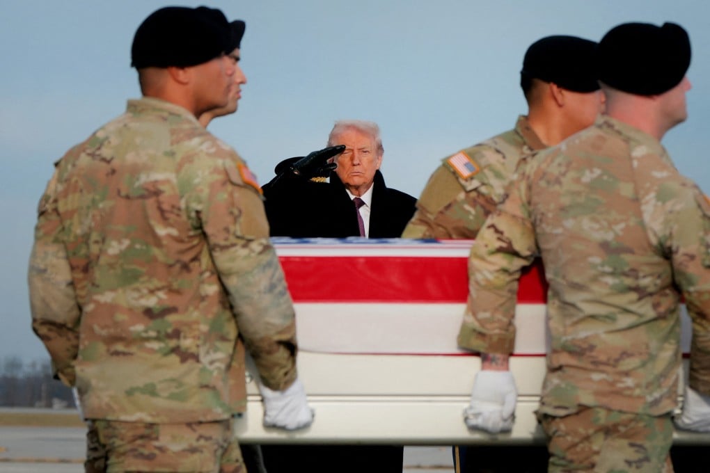 US President Donald Trump salutes as a US Army carry team moves a flagged-draped transfer case containing the remains of Ayad Mansoor Sakat, a US civilian working as an interpreter, at Dover Air Force Base in Delaware on Wednesday. Photo: AFP