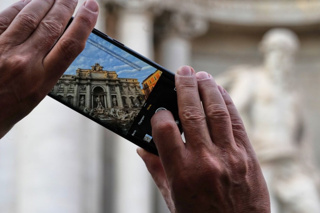 A visitor takes a photo of Rome’s Trevi Fountain on Friday. Photo: AP
