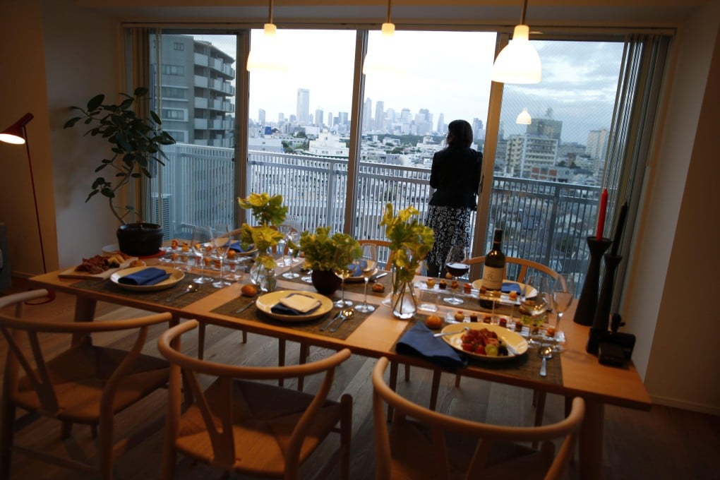 A visitor enjoys the balcony view during a 2013 preview of Tokyo’s Wine Apartment. Fifty-year mortgages in Japan offer young buyers affordability. Photo: Reuters