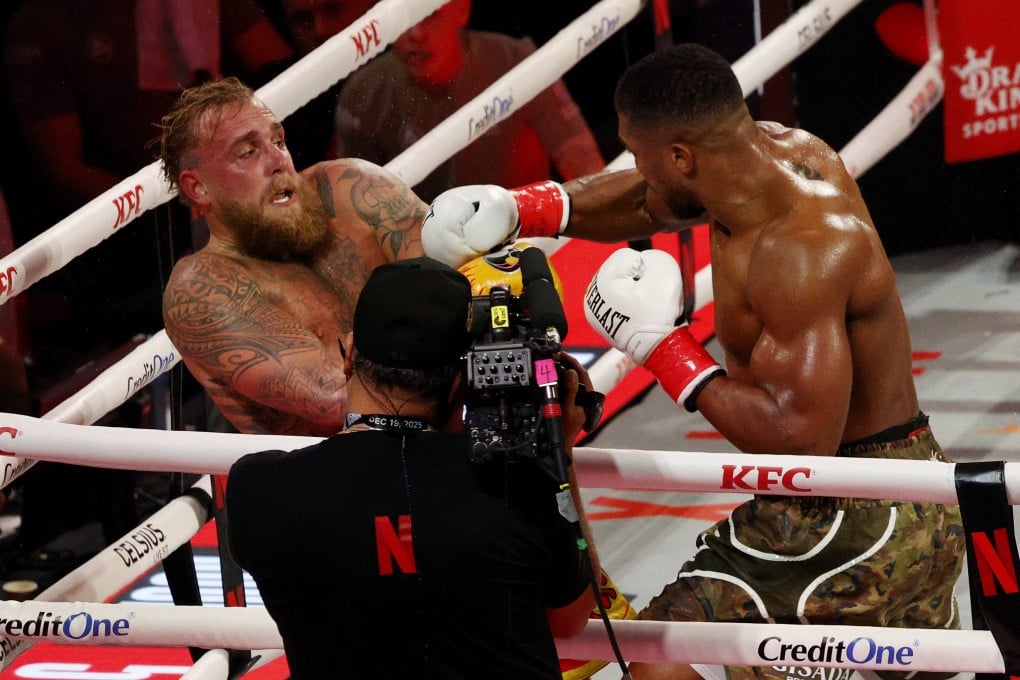 Jake Paul (left) does his best to avoid a swinging right hand from Anthony Joshua during their bout at the Kaseya Centre in Miami. Photo: Reuters