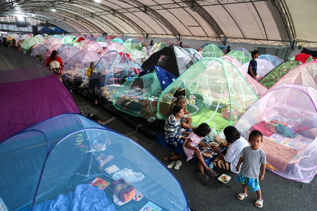Displaced people eat dinner at a temporary shelter in Thailand’s Buriram province on Tuesday. Photo: Reuters