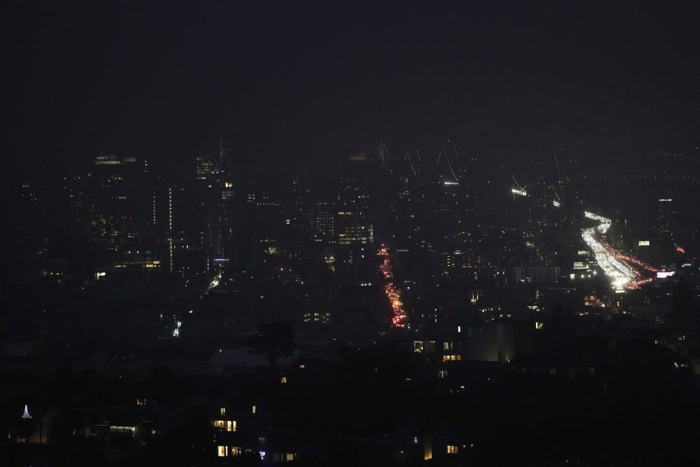Fog and power outages darken the skyline as traffic moves in San Francisco on Saturday. Photo: AP
