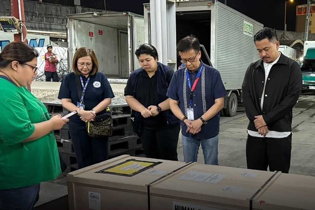 Secretary for Migrant Workers Hans Leo Cacdac (second from right) and others bow their heads next to the coffin of Maryan Pascual Esteban. Photo: Handout