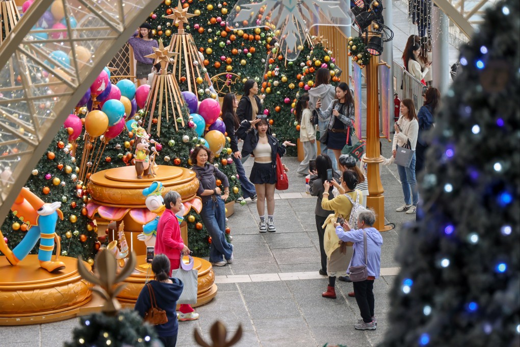 Tourists take photos under the Christmas decorations outside Ocean Terminal in Tsim Sha Tsui on December 19. Photo: Jelly Tse