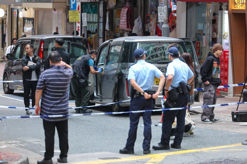 A police officer searches and collects evidence from a car on Jervois Street, Sheung Wan, believed to be linked to the robbery. Photo: Edmond So
