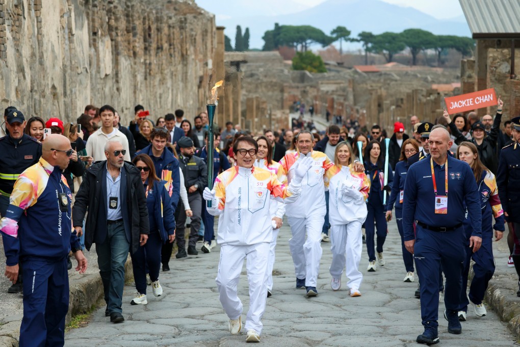 Actor Jackie Chan holds the olympic torch passing through the Archaeological Park in Pompeii. Photo: AP