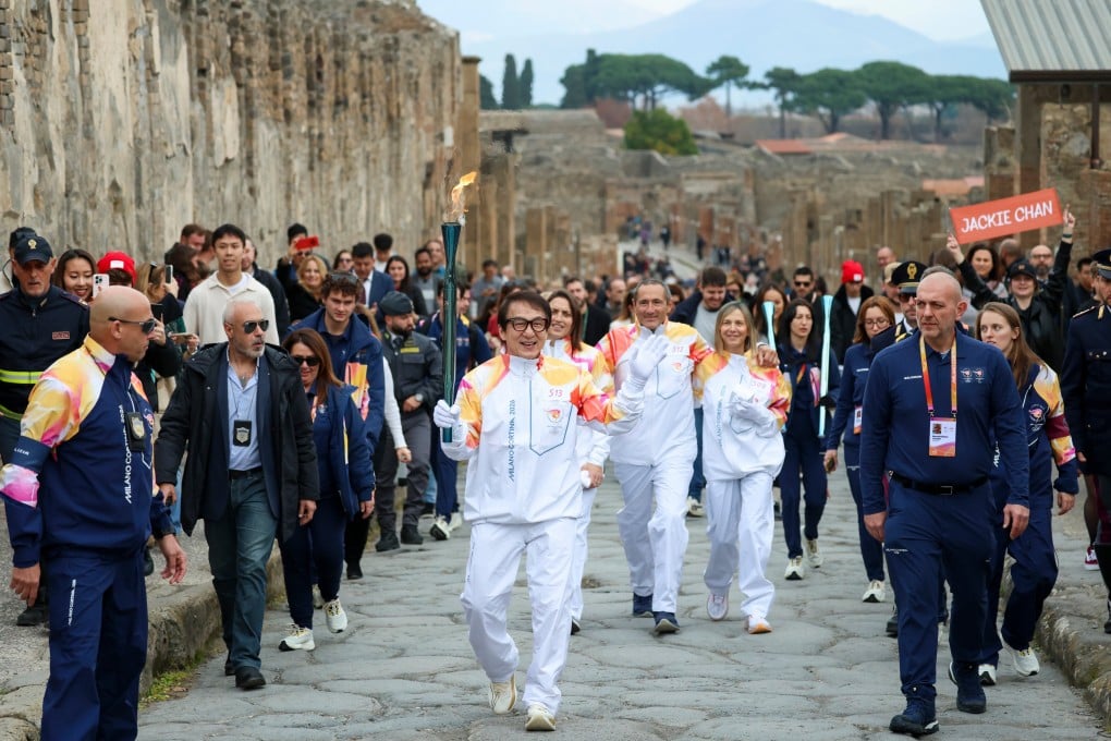 Actor Jackie Chan holds the olympic torch passing through the Archaeological Park in Pompeii. Photo: AP