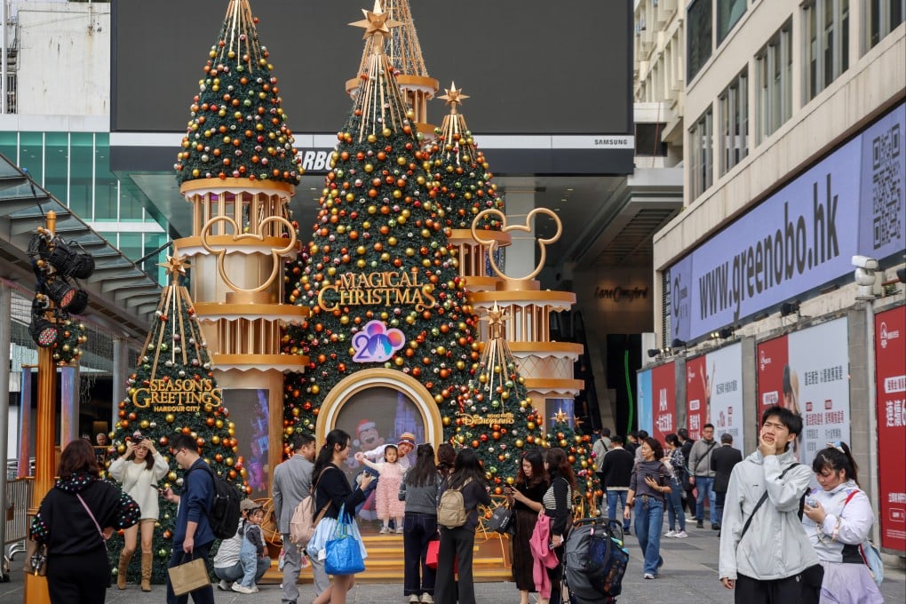 Tourists take photos under the Christmas decorations outside the Ocean Terminal in Tsim Sha Tsui. Photo: Jelly Tse