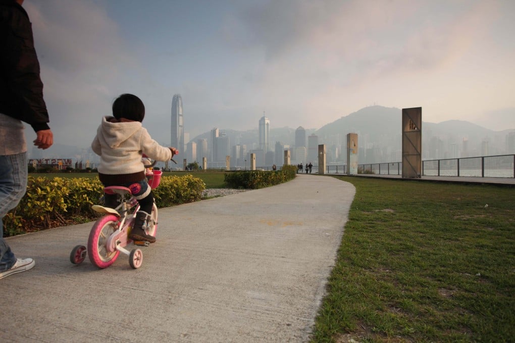 A child rides a bicycle towards the Hong Kong skyline in 2011. Photo: AFP