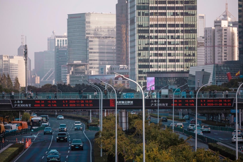 People walk across a bridge with a display showing the latest stock exchange and economic data in Shanghai, on November 28. Photo: EPA