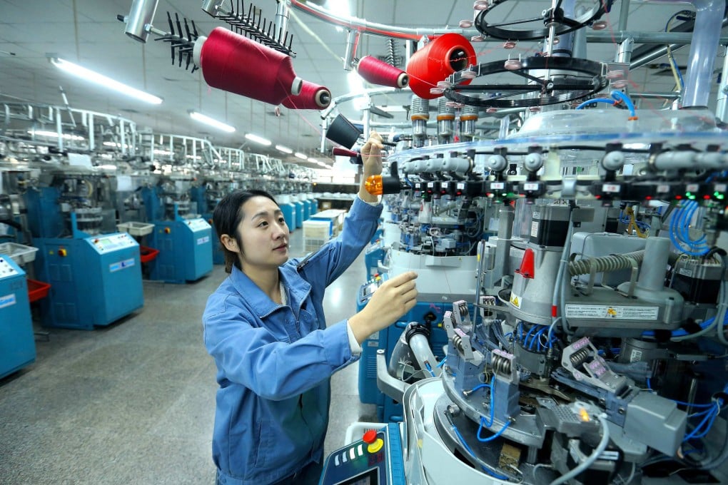 A worker operates machinery at a textile factory in Qingdao, in eastern China’s Shandong province on December 15. Photo: AFP