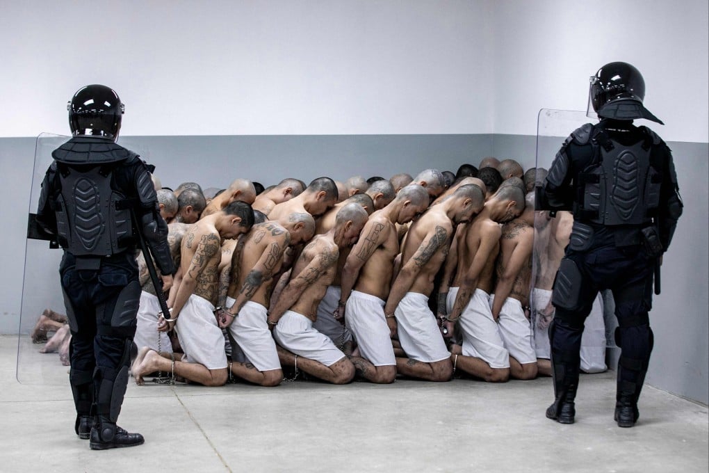 Police officers keep watch on new inmates at the CECOT facility in Tecoluca, El Salvador, in March 2023. Photo: El Salvador Presidency Press Office via AFP