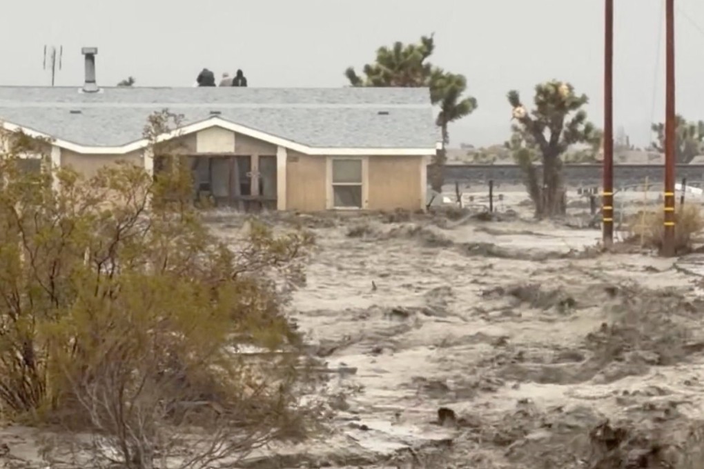 People sit on the roof of a building, stranded during floods in San Bernardino County in California on Christmas Eve, in this screengrab from a social media video. Photo: Timothy and the Machine Music/Facebook/via Reuters