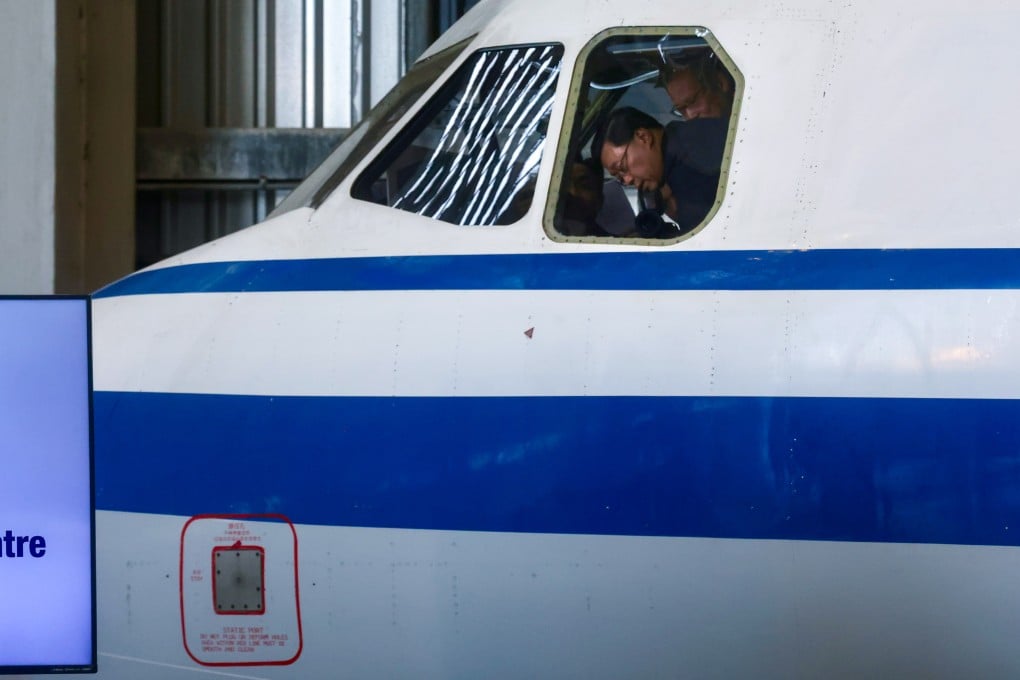 Chief Executive John Lee examines a cockpit at the launch of the Aircraft Engineering Training Centre in Chek Lap Kok on December 18. Photo: Jonathan Wong