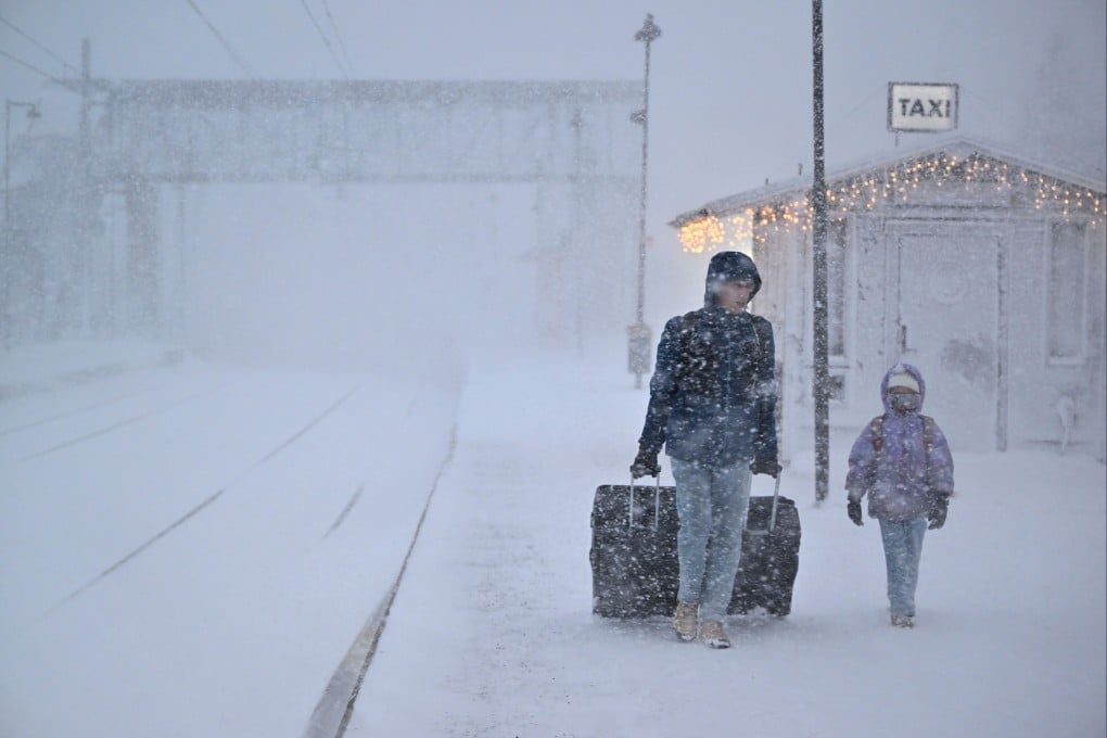 People walk in heavy snow as departures are cancelled at the train station in Are, Sweden on Saturday. Photo: TT News Agency via AP