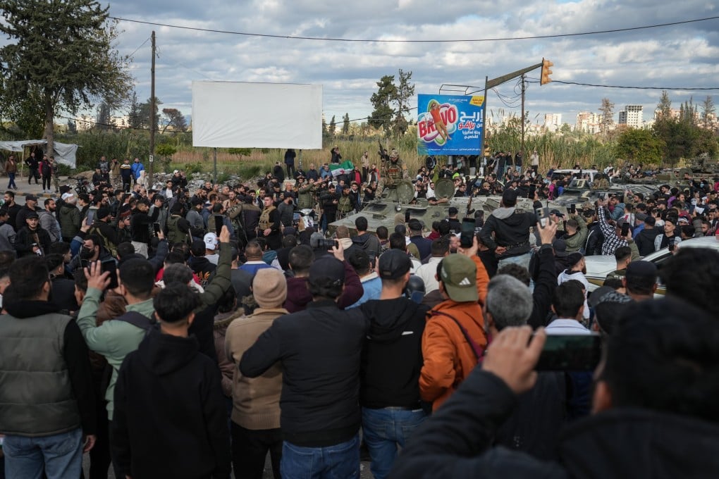 A crowd looks on as security forces are deployed after clashes erupted during a protest by members of the Alawite community in the city of Latakia, Syria on Sunday. Photo: EPA