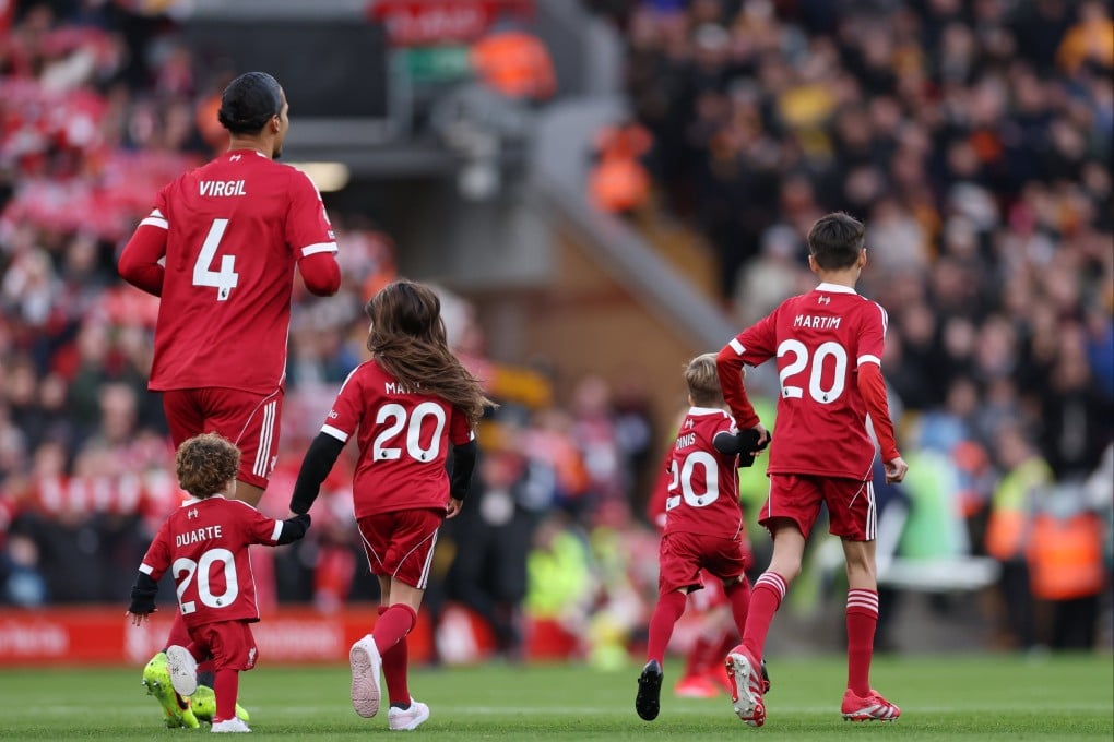 Two Diogo Jota’s children, Dinis (right) and Duarte (left) walk onto the pitch with Virgil van Dijk of Liverpool ahead of the Premier League match between Liverpool and Wolverhampton Wanderers on December 27. Photo: EPA