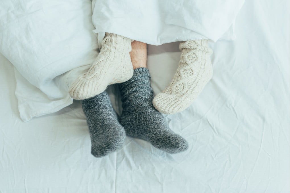Stay warm on cold nights with expert bedding tips, from heated blankets to sleeping with fuzzy socks on. Photo: Shutterstock