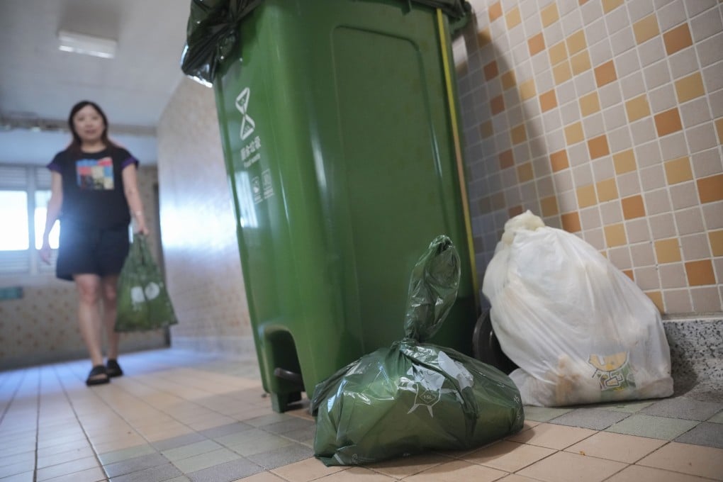 A resident of Hing Tung Estate in Sai Wan Ho uses a waste-charging bag on October 8, 2024. Photo: May Tse