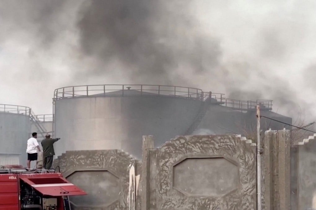 A video screengrab show a person gesture toward smoke after a Saudi-led airstrike on Tuesday targeting UAE-backed separatists in Mukalla, Yemen. Photo: Aden al-Mustakillah TV via Reuters