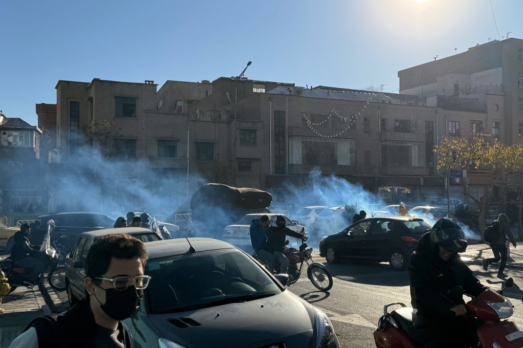 Iranian shopkeepers and traders protest against economic conditions as tear gas is fired by anti-riot police in Tehran, Iran on Monday. Photo: EPA