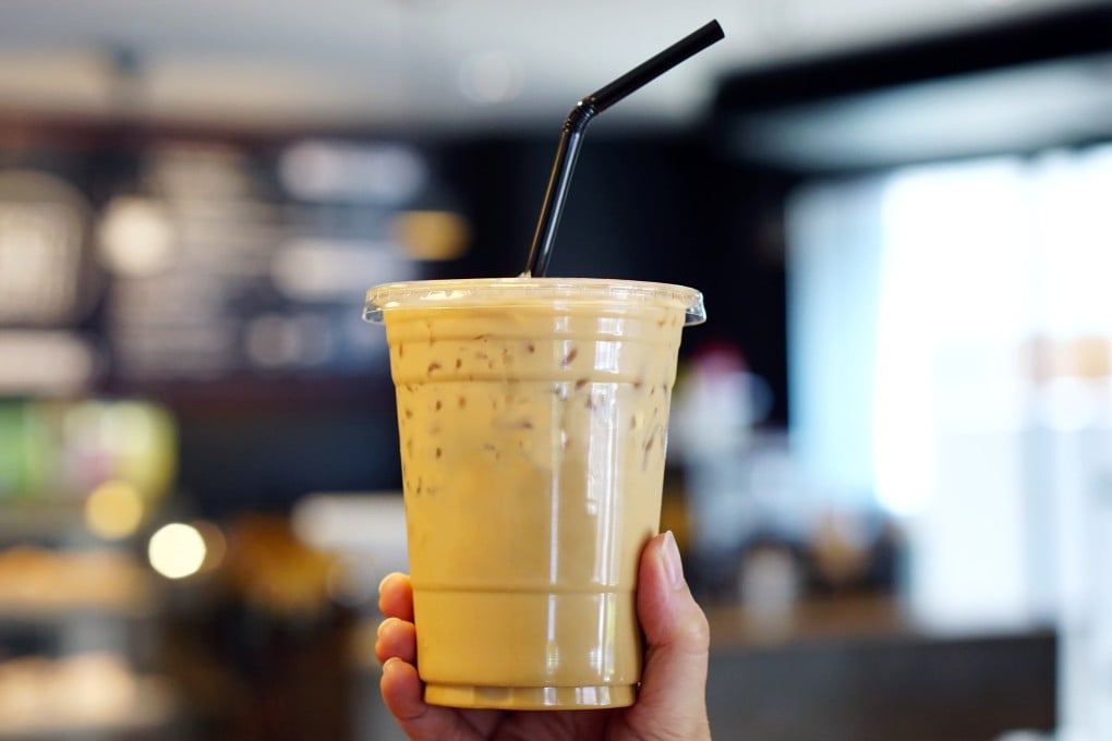 A woman holding plastic cup of iced coffee with milk. Photo: Shutterstock