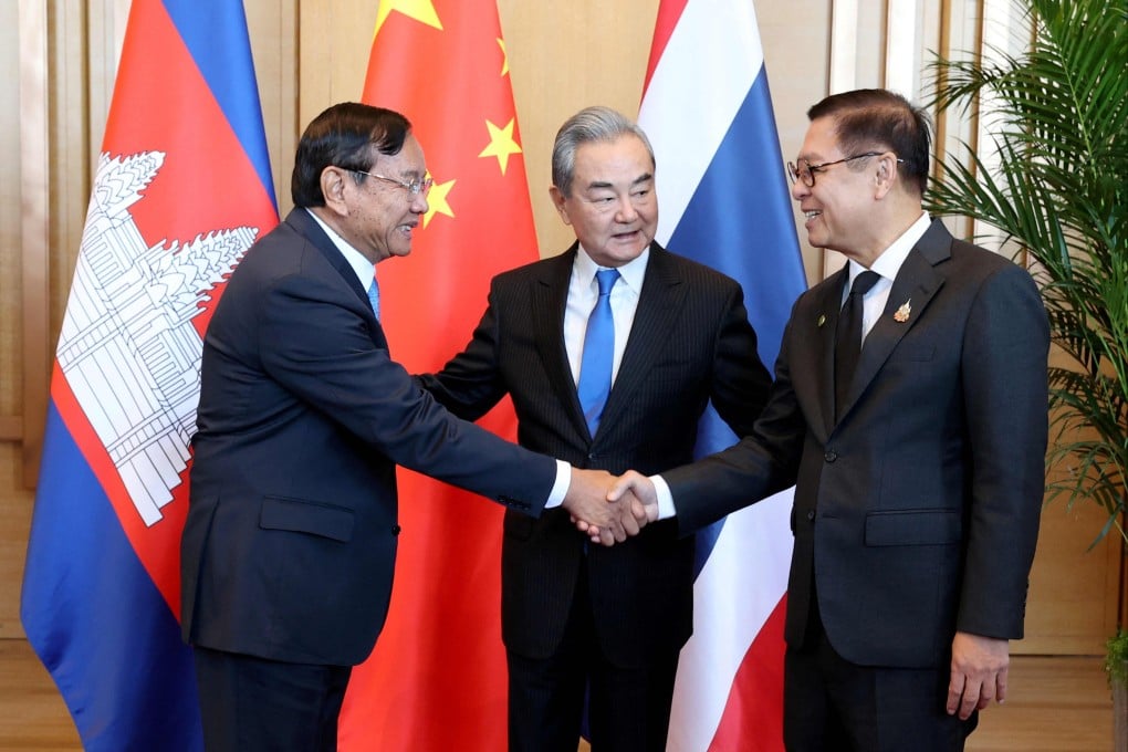 Chinese Foreign Minister Wang Yi (centre) embraces Cambodian Foreign Minister Prak Sokhonn (left) and Thai Foreign Minister Sihasak Phuangketkeow as they shake hands at a meeting in Yuxi, Yunnan province. Photo: Agence Kampuchea Press/AFP
