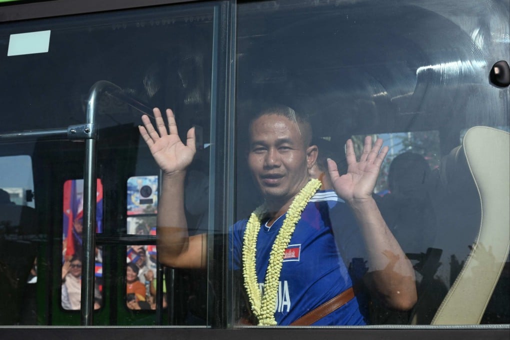 A Cambodian soldier, captured by Thai soldiers in July, waves from a bus after being released on Wednesday. Photo: AFP