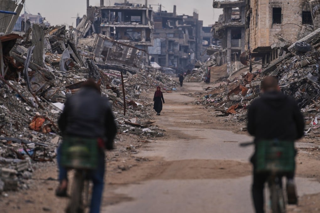 A Palestinian woman walks along a street surrounded by buildings destroyed during Israeli air and ground operations in Sheikh Radwan, a residential district of Gaza City, on December 30. Photo: AP
