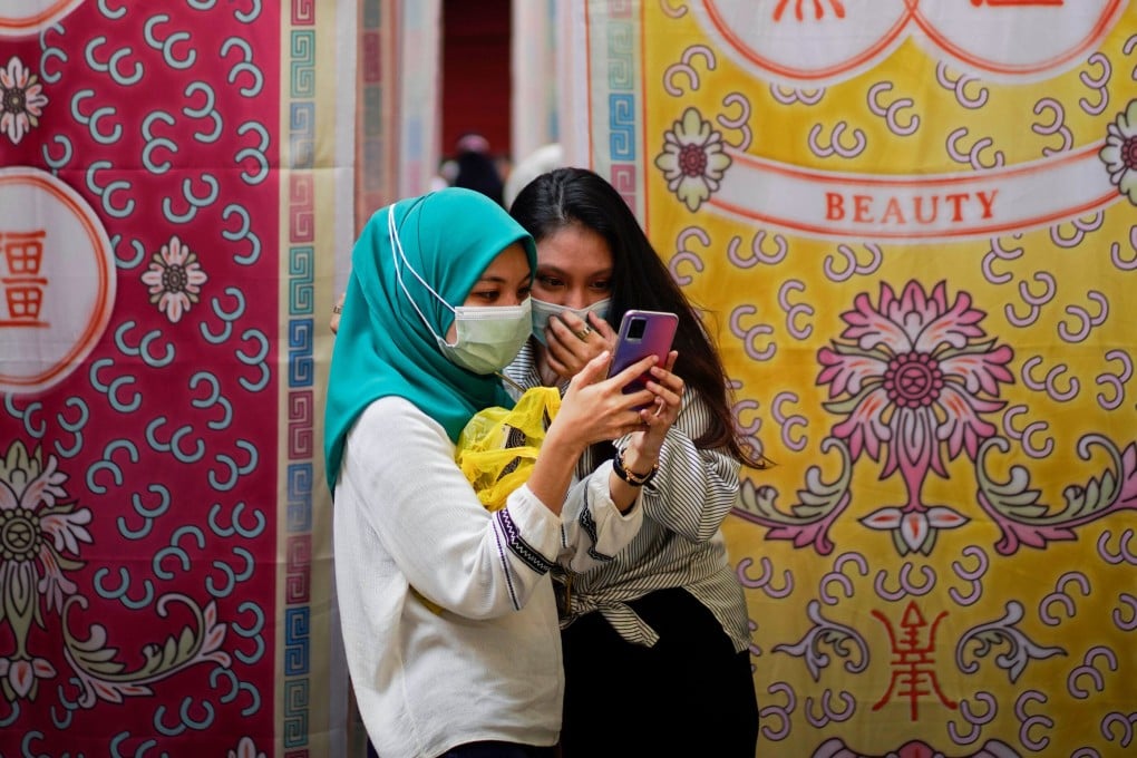 Young women using a smartphone in Kuala Lumpur, Malaysia. From January 1, major social media and messaging platforms with more than eight million users in Malaysia are treated as licensed under a new online safety regime. Photo: AP