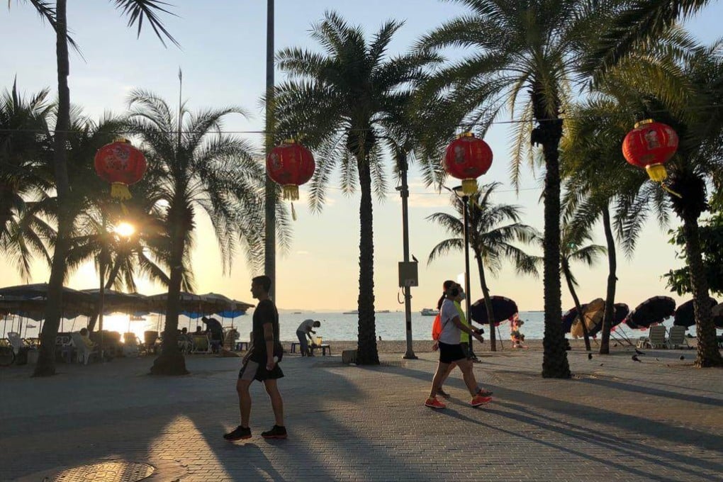 Red lanterns hang along South Pattaya beach as tourists walk past ahead of Chinese New Year. Photo: Vijitra Duangdee