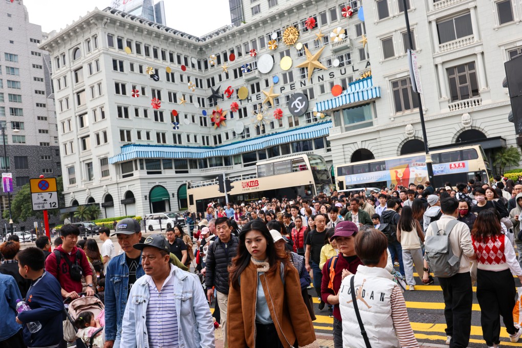 Travellers pass the Peninsula Hotel in Tsim Sha Tsui. Photo: Jelly Tse