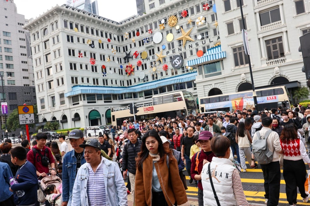 Travellers pass the Peninsula Hotel in Tsim Sha Tsui. Photo: Jelly Tse