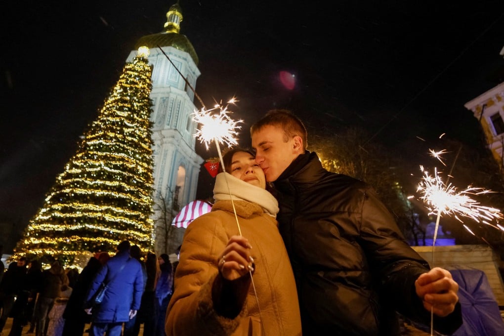 A couple kiss next to a Christmas tree in Kyiv, Ukraine, during celebrations before a curfew on December 31. Photo: Reuters
