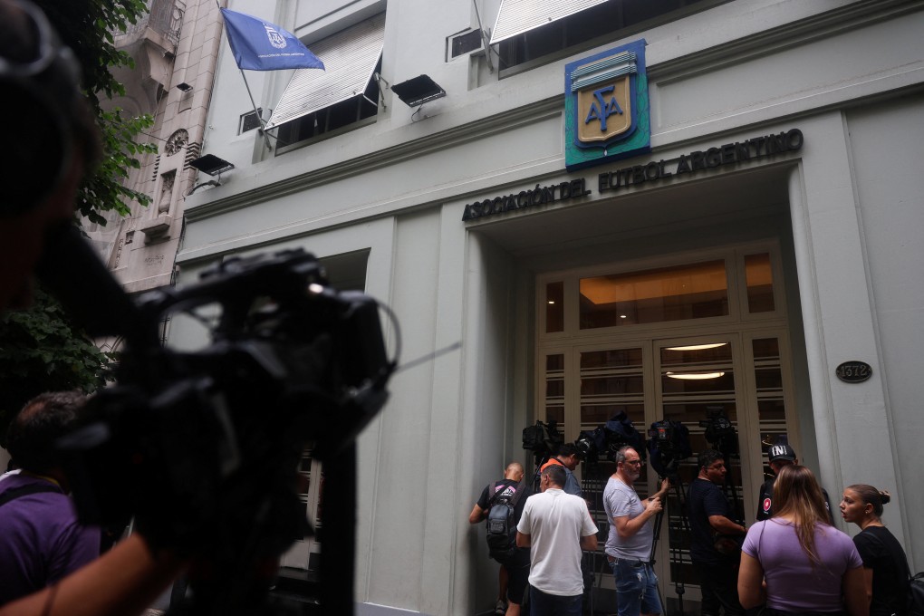 Members of the media take footage at the entrance of the Argentine Football Association headquarters after a police raid. Photo: Reuters