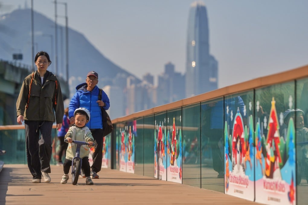 A boy in warm clothing rides a balance bike along the East Coast Boardwalk in Fortress Hill. Photo: Elson Li