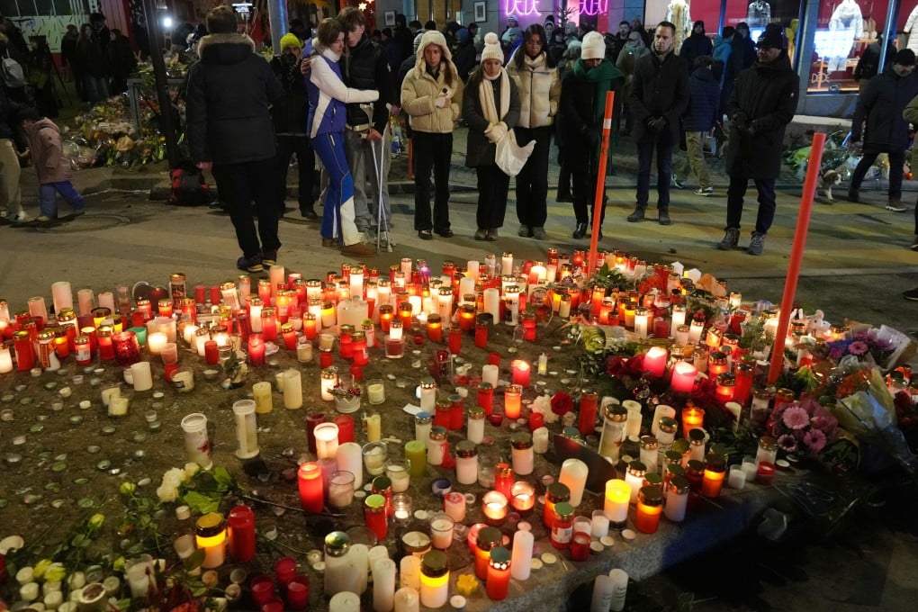 People light candles near the sealed Le Constellation bar in Crans-Montana, Switzerland on Friday where a devastating fire left 40 dead and dozens injured during the New Year celebrations. Photo; AP
