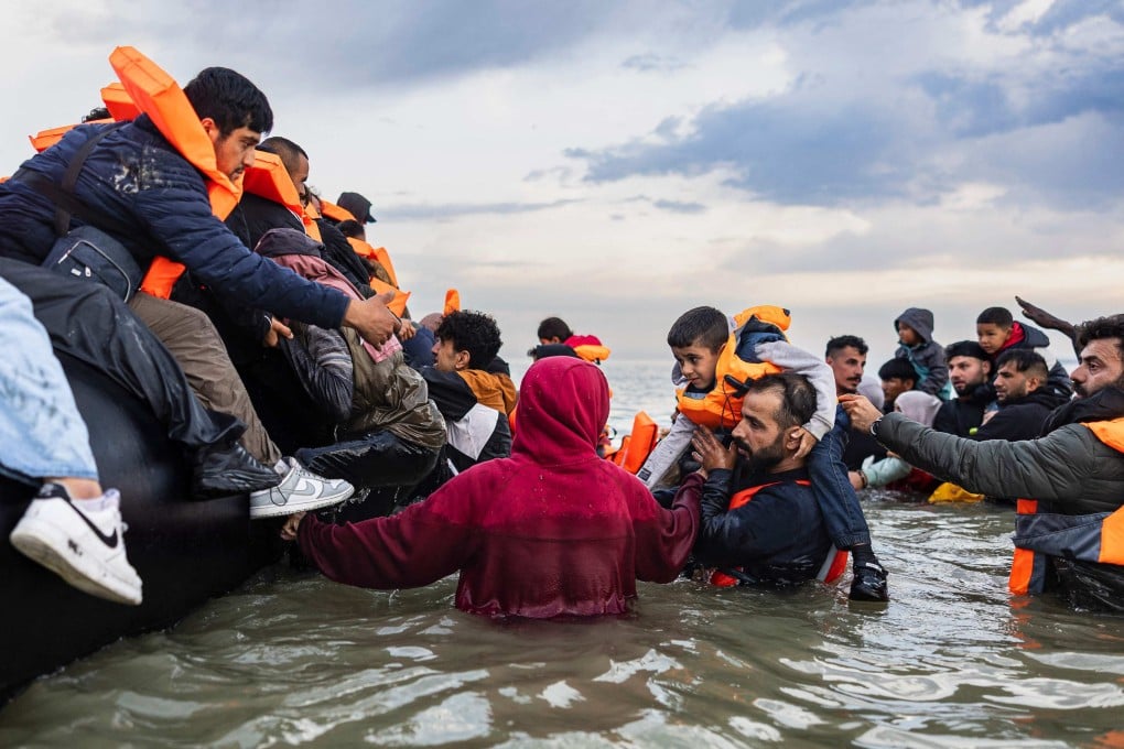 Migrants try to board a smuggler’s boat in an attempt to cross the English Channel off the beach of Gravelines, northern France. Photo: AFP
