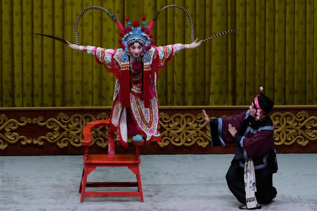 Peking opera actress Zhang Wanting (left) performs a difficult balancing move during a show at the Jixiang Theatre in Beijing, China. Photo: AP