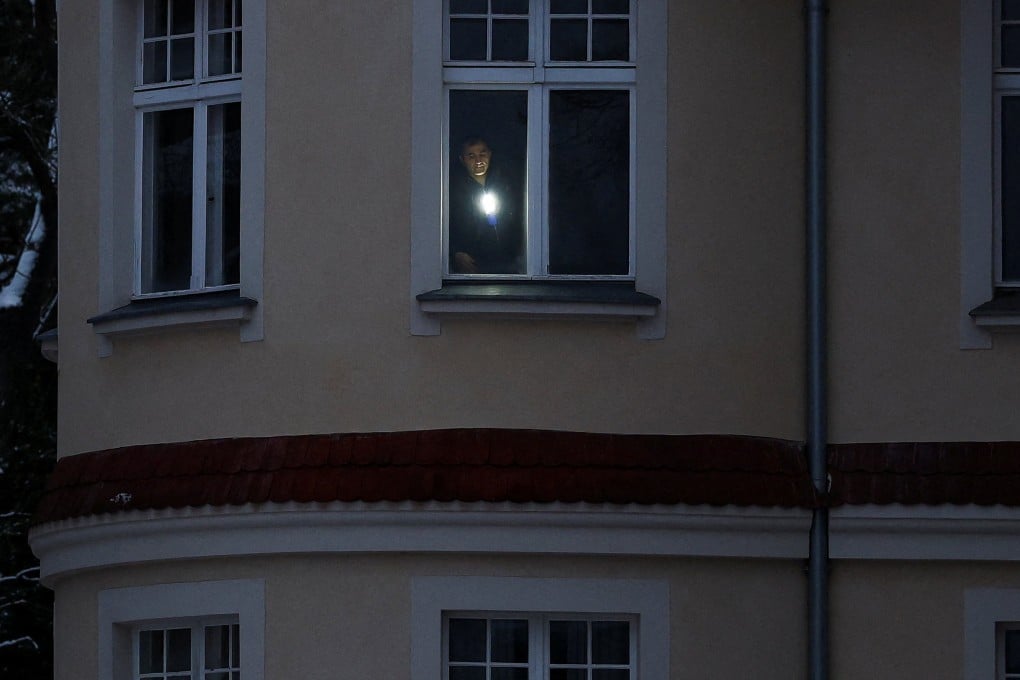 A man uses a torch in his flat during a blackout that left thousands of homes without electricity. Photo: Reuters