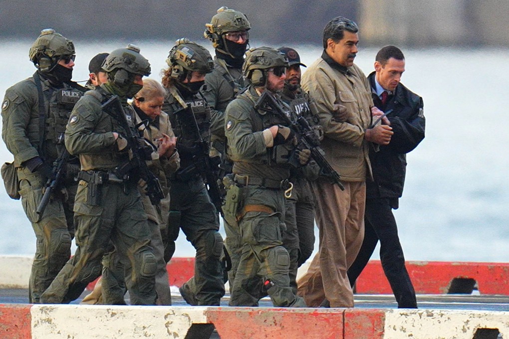 Nicolas Maduro and his wife, Cilia Flores, are seen in handcuffs after landing at a Manhattan helipad, escorted by heavily armed US agents as they make their way into an armoured car en route to a federal courthouse in Manhattan on Monday. Photo: XNY/Star Max/GC Images