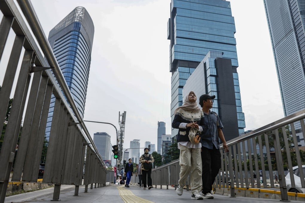 People walk along a sidewalk in Jakarta’s main business district. Indonesia’s new Criminal Code and revised Criminal Procedure Code came into force on Friday. Photo: EPA
