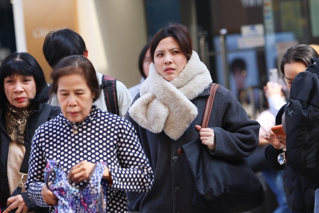 People walk past at Tsim Sha Tsui under the cold weather.  A Cold Weather Warning and a Strong Monsoon Signal are now in force. The temperature in Hong Kong has generally dropped to around 12 degrees this morning in the urban areas, and a further two to three degrees lower in the New Territories. Photo: Jelly Tse