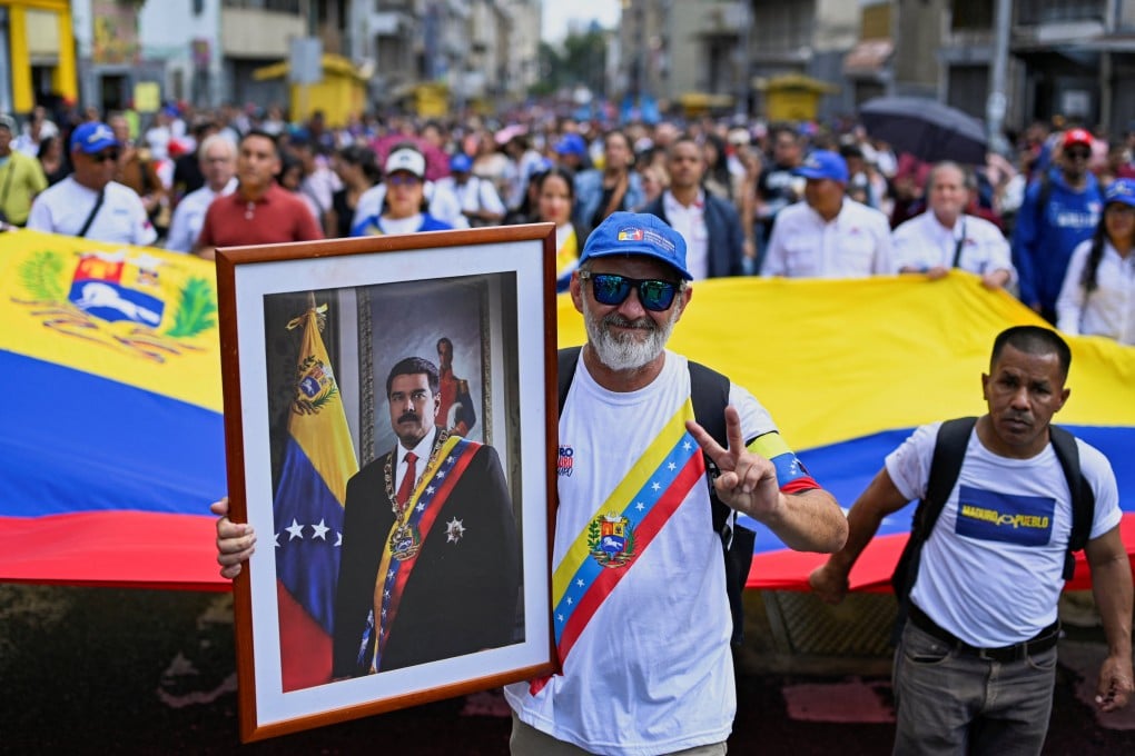A demonstrator holds a portrait of Venezuela’s Nicolas Maduro during a march outside the National Assembly in Caracas on Monday. Photo: Reuters