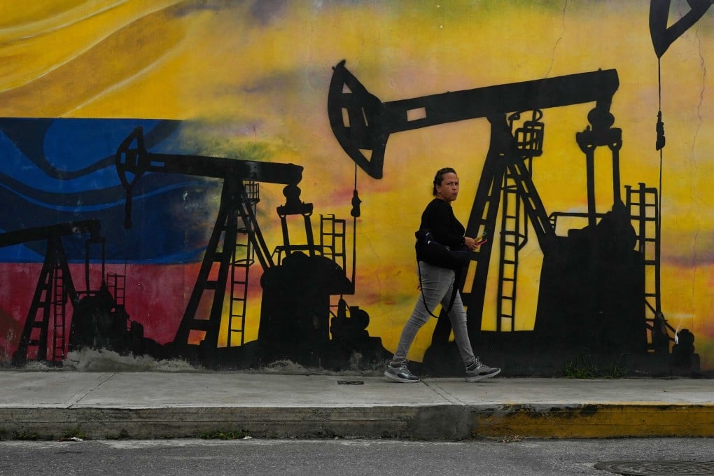 A local walks past a mural featuring oil pumps and wells in Caracas, Venezuela, on Tuesday. Photo: AP