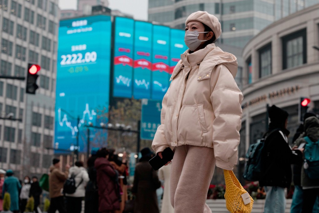 People walk past a jumbo screen displaying the latest stock exchange and economic data in Shanghai. Photo: EPA