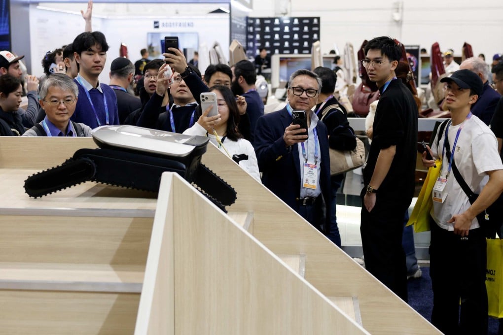 People at the CES trade show watch Dreame’s prototype Cyber X robot vacuum cleaner, the first such product designed to climb up and down an entire flight of stairs and handle multilevel cleaning. Photo: AFP