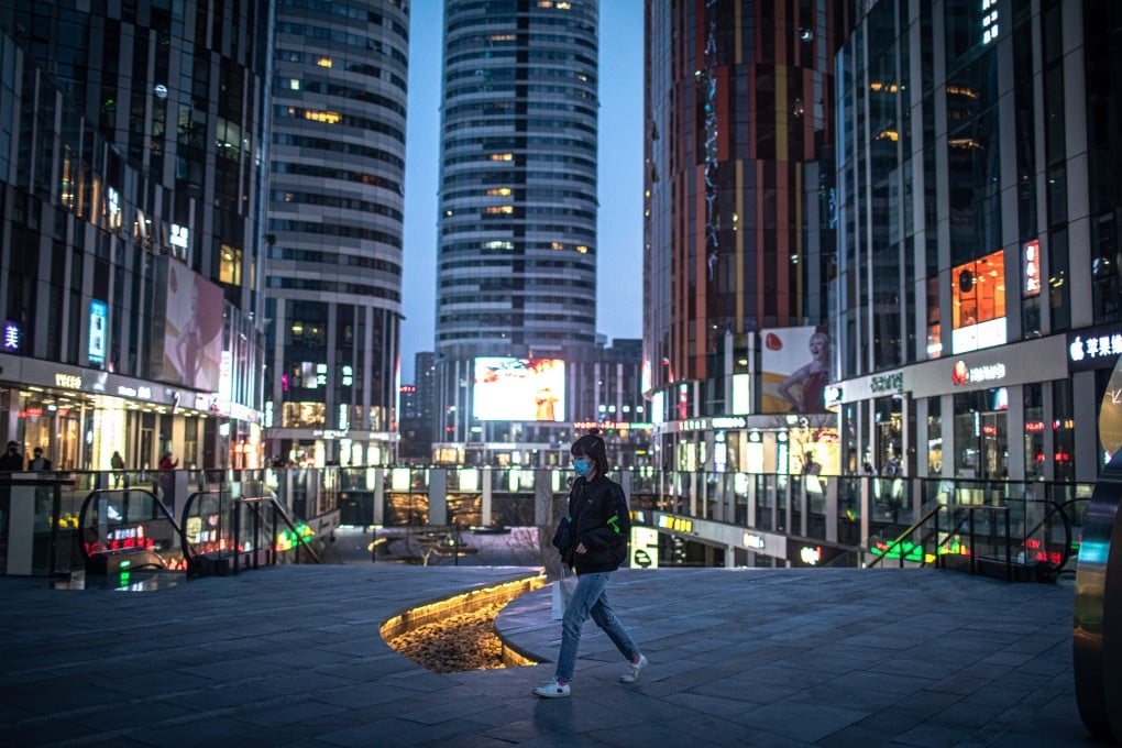 A woman walks in the nearly deserted shopping area of Sanlitun in Beijing in 2020. Photo: EPA-EFE