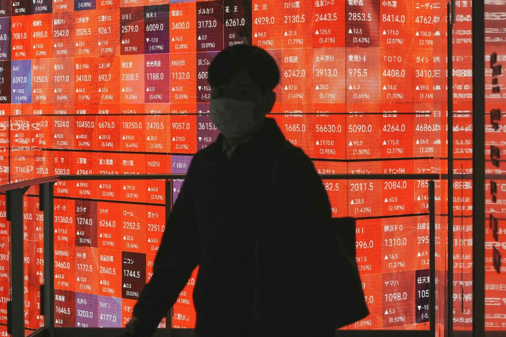 A man walks past an electronic board displaying the Nikkei 225 stock prices on the Tokyo Stock Exchange in Tokyo on January 5. Photo: AFP