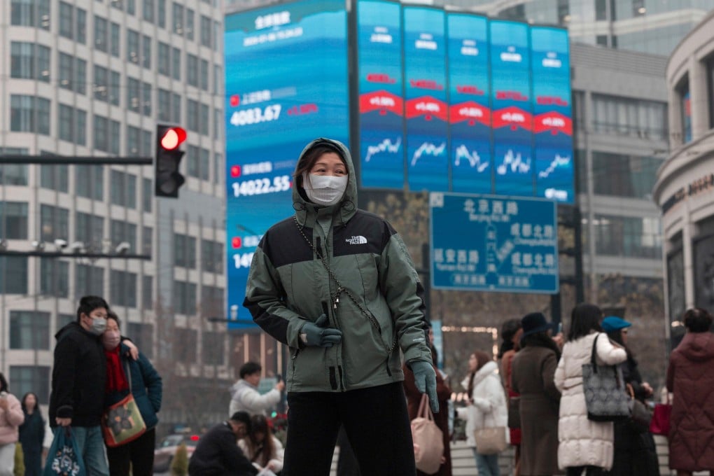People walk below a large screen displaying the latest stock exchange and economic data in Shanghai on January 6. Photo: EPA
